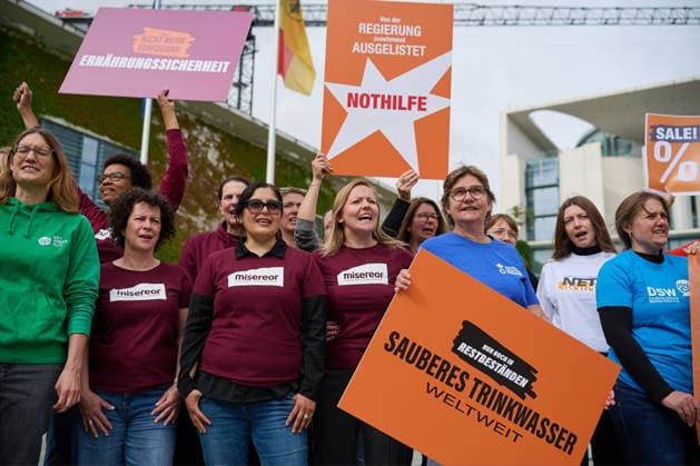 Ein Buendnis aus 15 Hilfsorganisationen protestiert am Montag (06.07.2026) vor dem Bundeskanzleramt in Berlin gegen Kuerzungen in der Entwicklungszusammenarbeit. Bei der Aktion Menschenwuerde im Ausverkauf fordern die Organisationen Aenderungen im Bundeshaushalt 2027. Dem Buendnis gehoeren unter anderem Brot fuer die Welt, misereor, Oxfam Deutschland sowie die Welthungerhilfe an. (Siehe epd-Meldung vom 06.07.2026) EDITORIAL USE ONLY *** A coalition of 15 aid organizations will protest on Monday, July 6, 2026, in front of the Federal Chancellery in Berlin against cuts to development cooperation. As part of the campaign Human Dignity on Sale, the organizations are calling for changes to the 2027 federal budget. The coalition includesinclu Copyright: epd-bild ChristianxDitsch epd-Protest_Kuerzungen6-kopieren