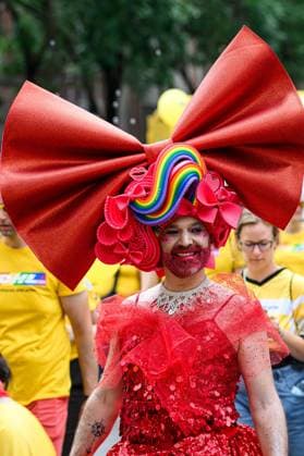 COLOGNE, GERMANY - 5 JULY, 2026: Drag performer in a red sequined costume and oversized bow walks during Street Parade of the Christopher Street Day (CSD), Gay Pride. LGBT.  Copyright: xx