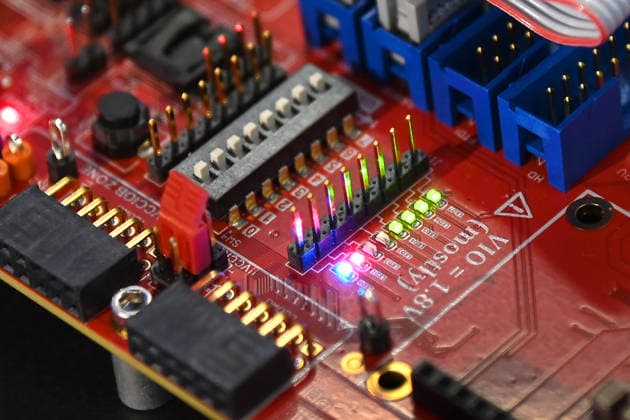 Nahaufnahme einer roten Elektronikplatine mit Steckverbindern, DIP-Schalter, Stiftleisten und Flachbandkabel. 5.Bayerischer Halbleiter-Kongress am 06.07.2026 in Muenchen. *** Close-up of a red circuit board with connectors, DIP switches, pin headers, and ribbon cables 5th Bavarian Semiconductor Congress on July 6, 2026, in Munich