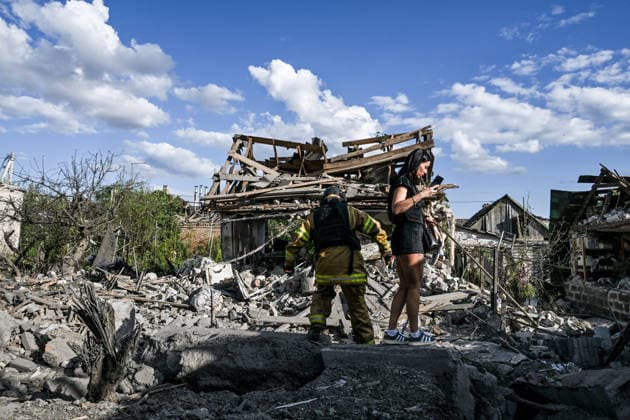 RECORD DATE NOT STATED A woman and a rescuer stand in front of a residential building destroyed in a Russian guided bomb attack in Zaporizhzhia, Ukraine, on July 5, 2026. Russian forces struck the city with two guided aerial bombs. One bomb hit near a multi-storey residential building, while the other struck a private residential area. The attack damaged 35 apartments in the apartment building and destroyed private homes. More than ten people were injured, and a police officer was killed (Photo by Dmytro Smolienko Ukrinform) Russian forces strike Zaporizhzhia with two guided bombs  Copyright: xDmytroxSmolienkox