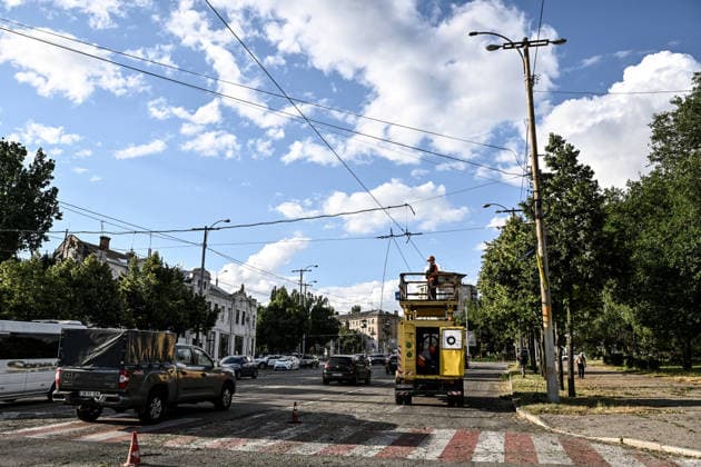 RECORD DATE NOT STATED Cars pass by electrical workers repairing the electric public transport network damaged in a Russian guided bomb attack in Zaporizhzhia, Ukraine, on July 5, 2026. Russian forces struck the city with two guided aerial bombs. One bomb hit near a multi-storey residential building, while the other struck a private residential area. The attack damaged 35 apartments in the apartment building and destroyed private homes. More than ten people were injured, and a police officer was killed (Photo by Dmytro Smolienko Ukrinform) Russian forces strike Zaporizhzhia with two guided bombs  Copyright: xDmytroxSmolienkox