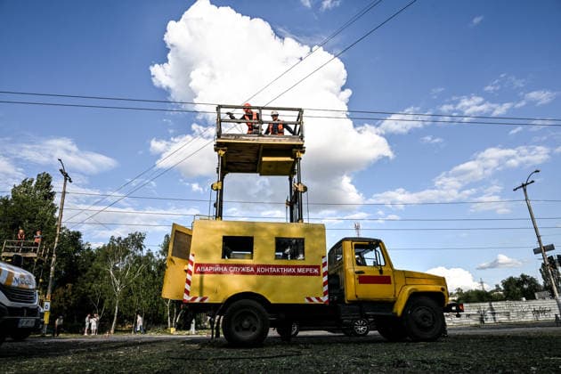 RECORD DATE NOT STATED Cars pass by electrical workers repairing the electric public transport network damaged in a Russian guided bomb attack in Zaporizhzhia, Ukraine, on July 5, 2026. Russian forces struck the city with two guided aerial bombs. One bomb hit near a multi-storey residential building, while the other struck a private residential area. The attack damaged 35 apartments in the apartment building and destroyed private homes. More than ten people were injured, and a police officer was killed (Photo by Dmytro Smolienko Ukrinform) Russian forces strike Zaporizhzhia with two guided bombs  Copyright: xDmytroxSmolienkox