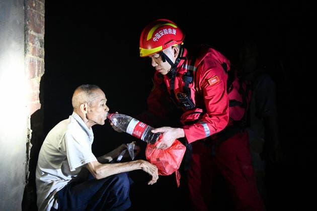 (260707) -- HENGZHOU, July 7, 2026 -- A rescuer feeds water to an elderly villager in Hengzhou of Nanning City, south China s Guangxi Zhuang Autonomous Region, July 6, 2026. Record-breaking rainfall and the ensuing floods in parts of Nanning, capital city of south China s Guangxi Zhuang Autonomous Region, have left four people dead and eight others missing as of 10 a.m. Tuesday, according to a press conference on flood prevention and disaster relief held in Nanning. Hengzhou City and Binyang County, both currently under the jurisdiction of Nanning, recently experienced rainfall that broke local 24-hour meteorological records. The reported casualties were all in Hengzhou. ) CHINA-GUANGXI-NANNING-FLOOD-RESCUE (CN) CaoxYiming 