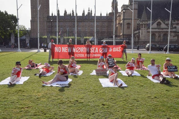 July 7, 2026, London, England, United Kingdom: Climate activists from the group Fossil Free London don swimming costumes and stage a Ã¢â‚¬Ëœsunbathe-inÃ¢â‚¬â ¢ protest dubbed Roast Against Rosebank in Parliament Square calling on the government to stop new North Sea oil and gas projects, as another heatwave hits the UK. London United Kingdom  - ZUMAv130 20260707_zip_v130_001 Copyright: xVukxValcicx