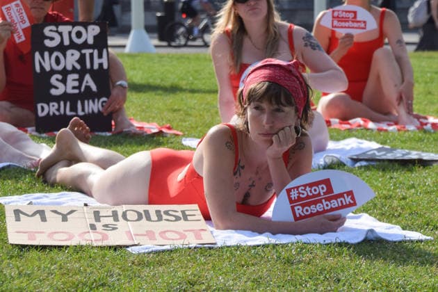 July 7, 2026, London, England, United Kingdom: Climate activists from the group Fossil Free London don swimming costumes and stage a Ã¢â‚¬Ëœsunbathe-inÃ¢â‚¬â ¢ protest dubbed Roast Against Rosebank in Parliament Square calling on the government to stop new North Sea oil and gas projects, as another heatwave hits the UK. London United Kingdom - ZUMAv130 20260707_zip_v130_002 Copyright: xVukxValcicx