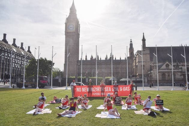 July 7, 2026, London, England, United Kingdom: Climate activists from the group Fossil Free London don swimming costumes and stage a Ã¢â‚¬Ëœsunbathe-inÃ¢â‚¬â ¢ protest dubbed Roast Against Rosebank in Parliament Square calling on the government to stop new North Sea oil and gas projects, as another heatwave hits the UK. London United Kingdom - ZUMAv130 20260707_zip_v130_004 Copyright: xVukxValcicx