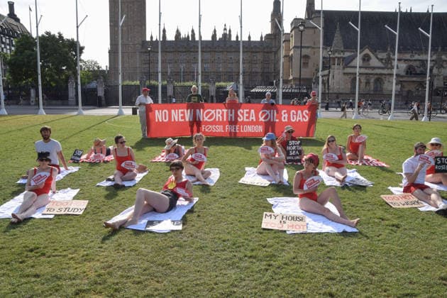 July 7, 2026, London, England, United Kingdom: Climate activists from the group Fossil Free London don swimming costumes and stage a Ã¢â‚¬Ëœsunbathe-inÃ¢â‚¬â ¢ protest dubbed Roast Against Rosebank in Parliament Square calling on the government to stop new North Sea oil and gas projects, as another heatwave hits the UK. London United Kingdom - ZUMAv130 20260707_zip_v130_005 Copyright: xVukxValcicx
