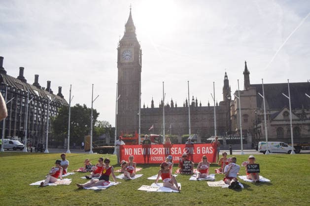 July 7, 2026, London, England, United Kingdom: Climate activists from the group Fossil Free London don swimming costumes and stage a Ã¢â‚¬Ëœsunbathe-inÃ¢â‚¬â ¢ protest dubbed Roast Against Rosebank in Parliament Square calling on the government to stop new North Sea oil and gas projects, as another heatwave hits the UK. London United Kingdom  - ZUMAv130 20260707_zip_v130_006 Copyright: xVukxValcicx