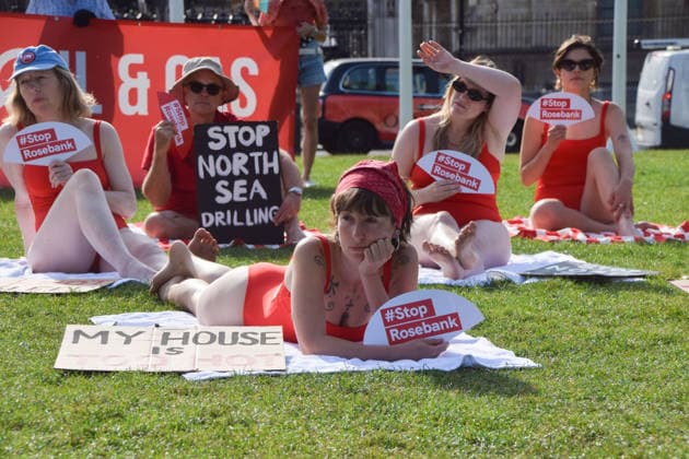 July 7, 2026, London, England, United Kingdom: Climate activists from the group Fossil Free London don swimming costumes and stage a Ã¢â‚¬Ëœsunbathe-inÃ¢â‚¬â ¢ protest dubbed Roast Against Rosebank in Parliament Square calling on the government to stop new North Sea oil and gas projects, as another heatwave hits the UK. London United Kingdom - ZUMAv130 20260707_zip_v130_008 Copyright: xVukxValcicx
