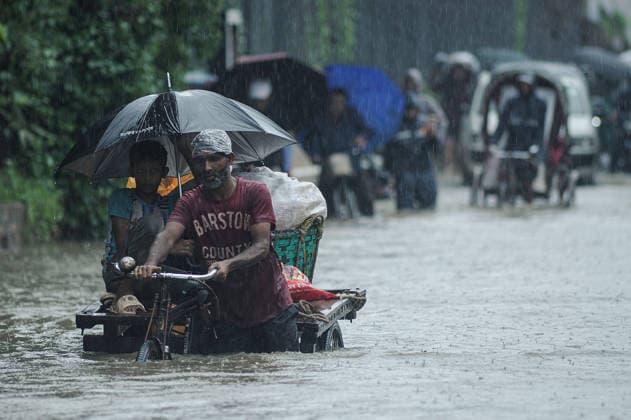 July 7, 2026: Chattogram, Bangladesh - Pedestrians, rickshaw pullers, and commuters navigate a waterlogged street in the Bahaddarhat area of Chattogram on Tuesday, continuing three consecutive days of heavy rainfall. The persistent downpours triggered severe waterlogging across several parts of the port city, submerging roads, disrupting traffic, and causing widespread inconvenience to residents. - ZUMAr143 20260707_zap_r143_029 Copyright: xMdxRafayatxHaquexKhanx