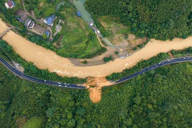 (260707) -- LAIBIN, July 7, 2026 -- An aerial drone photo taken on July 7, 2026 shows emergency restoration of a damaged highway in Qingshan Village of Jinxiu Yao Autonomous County, Laibin City, south China s Guangxi Zhuang Autonomous Region. Recent extreme rainstorms triggered by Typhoon Maysak, the 10th typhoon of the year, have caused severe flooding in parts of south China s Guangxi Zhuang Autonomous Region. Traffic of several national and provincial highways in Jinxiu Yao Autonomous County has been disrupted. Emergency restoration of the damaged roads is underway. (Photo by Xinhua) (SpotNews) CHINA-GUANGXI-LAIBIN-TYPHOON-DAMAGED ROADS (CN) GaoxRujin 