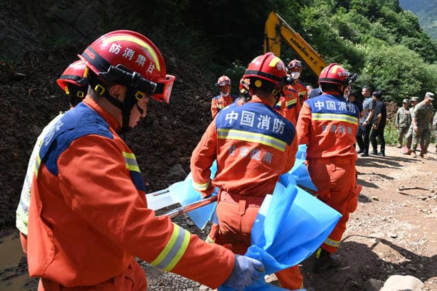 (260707) -- TANCHANG, July 7, 2026 -- Rescuers work at the site of a landslide in a village in Nanhe Township, Tanchang County, Longnan City, northwest China s Gansu Province, July 7, 2026. China s Ministry of Emergency Management activated a Level-IV national emergency response for geological disasters in northwest China s Gansu Province and dispatched a working team to guide rescue and relief efforts after a landslide struck a village on Tuesday, leaving multiple people buried and dead. The landslide occurred at around 6:56 a.m. in a village in Nanhe Township, Tanchang County, Longnan City, according to local authorities. A total of 33 people were buried beneath the debris. As of 2:50 p.m., 21 people had been pulled from the debr 