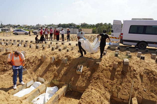 Red Cross teams examined the mass grave in the Deir al-Balah DEIR AL-BALAH, GAZA, PALESTINE - JULY 7: Officials of the International Committee of the Red Cross (ICRC) carry remains to ambulances to collect samples from bodies for DNA testing during an investigation at a mass grave for unidentified victims of Israeli attacks in Deir al-Balah, Gaza, Palestine on July 07, 2026. Anas Zeyad Fteha Anadolu Deir al-Balah Gaza. Editorial use only. Please get in touch for any other usage.  Copyright: x2026xAnadoluxAnasxZeyadxFtehax