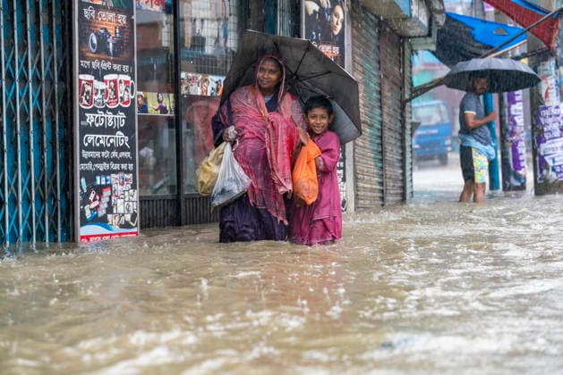 Bangladesh: Severe Waterlogging Paralyzes Chattogram Amid Heavy Monsoon Rain In Chattogram A pregnant woman with a child holds an umbrella as they wade through a flooded street during heavy rain in Chattogram, Bangladesh, on July 7, 2026. Torrential monsoon downpours have triggered severe waterlogging in major parts of the port city, causing widespread disruption to normal life. Chattogram Bangladesh  Copyright: xZakirxHossainx originalFilename: hossain-notitle260707_nprmR.jpg