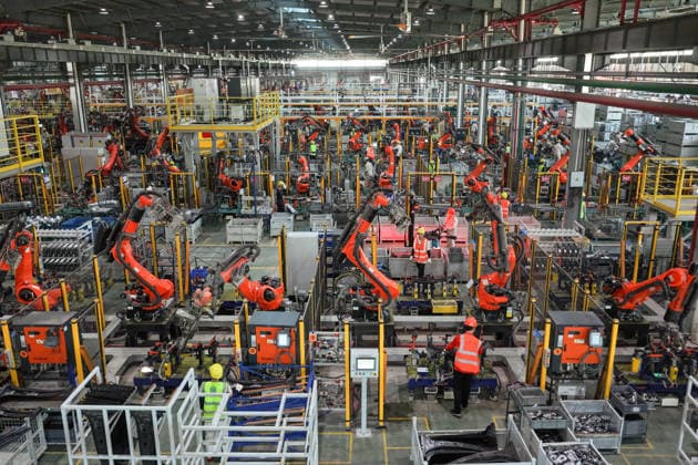 JINHUA, CHINA - JULY 07: Industrial robots operate at full speed while workers rush to fulfill orders for new energy vehicle parts at the production workshop of Jinhua Zhixin Technology Co., Ltd. in Jinhua, Zhejiang Province of China on July 7, 2026.  Copyright: xVCGx 111652834353