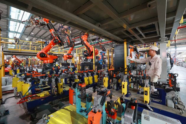 JINHUA, CHINA - JULY 07: Industrial robots operate at full speed while workers rush to fulfill orders for new energy vehicle parts at the production workshop of Jinhua Zhixin Technology Co., Ltd. on July 7, 2026 in Jinhua, Zhejiang Province of China.  Copyright: xVCGx 111652834349