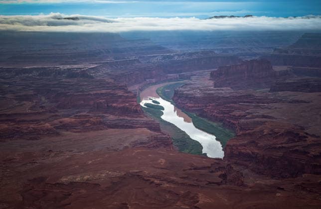 Dramatic aerial view of river winding through vast red canyon Moab, Utah, United States CR_EVVA260610-2047366-01