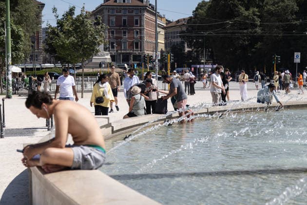IPA86509551 - Milan, July 8, 2026, Piazza Castello, Largo Cairoli, Milan, July 8, 2026, Piazza Castello, Largo Cairoli, Summer heat wave with exceptionally high temperatures; in the city center, in front of the Sforza Castle, a tourist finds relief in the fountain while sunbathing  Copyright: xFrancescoxEnriquezx xFrancescoxEnriquezx 86509551