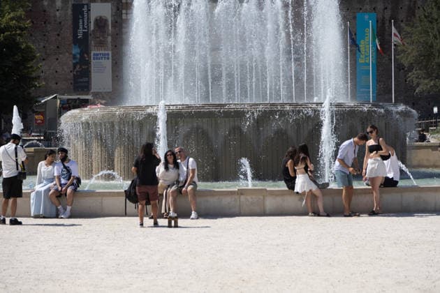 IPA86509332 - Milan, July 8, 2026, Piazza Castello, Largo Cairoli, Milan, July 8, 2026, Piazza Castello, Largo Cairoli, Summer heat wave with exceptionally high temperatures; in the city center, in front of the Sforza Castle, a tourist finds relief in the fountain while sunbathing  Copyright: xFrancescoxEnriquezx xFrancescoxEnriquezx 86509332