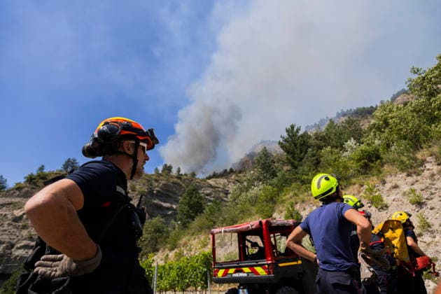 Wildfire Threatens Village Of Aurel - France A huge plume of smoke rises from the wildfire just above a team of firefighters monitoring its progress. A wildfire is currently burning in the Drome region, where it is dangerously approaching the village of Aurel. France, Drome, Aurel, July 8, 2026. Photo by Thibaut Durand ABACAPRESS.COM Aurel Auvergne-Rhone-Alpes France  Copyright: xDurandxThibaut ABACAx