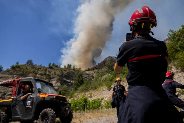 Wildfire Threatens Village Of Aurel - France A huge plume of smoke rises from the wildfire just above a team of firefighters monitoring its progress. A wildfire is currently burning in the Drome region, where it is dangerously approaching the village of Aurel. France, Drome, Aurel, July 8, 2026. Photo by Thibaut Durand ABACAPRESS.COM Aurel Auvergne-Rhone-Alpes France  Copyright: xDurandxThibaut ABACAx
