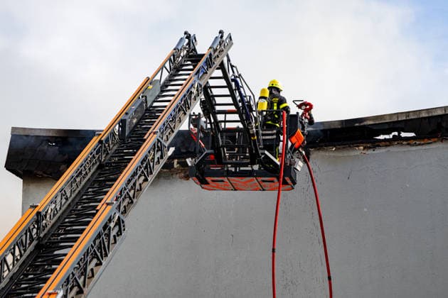 Wohnungsbrand greift auf Dachstuhl über Dach auf 60 mal 10 Metern in Vollbrand Am 08.07.2026 kam es in Frankfurt-Schwanheim gegen 15:50 Uhr zu einem Wohnungsbrand im dritten Obergeschoss eines Mehrfamilienhauses, der noch vor Eintreffen der Feuerwehr auf den Dachstuhl übergriff. Die Berufsfeuerwehr und die Freiwillige Feuerwehr Frankfurt bekämpften den Dachbrand auf einer Fläche von 60 mal 10 Metern mit acht Rohren vom Boden sowie über vier Drehleitern. Aufgrund der Thermik zog der Rauch nicht ab, sondern breitete sich über umliegende Straßen aus, weshalb die Polizei per Lautsprecher zum Schließen von Fenstern und Türen aufrief und zusätzlich über Medien gewarnt wurde. Die Brandwohnung brannte komplett aus und ist nicht mehr
