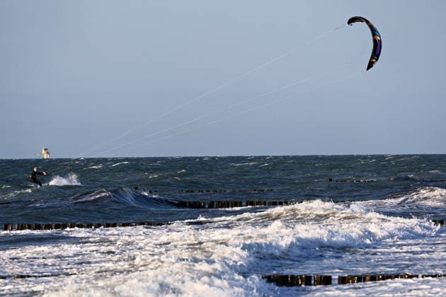 20260708 Strandidylle an der Ostsee bei Börgerenede-Rethwisch, einer Gemeinde im Landkreis Rostock in Mecklenburg-Vorpommern. Touristen und Urlauber flannieren am Strand, sitzen in Campingstühlen, bauen Sandburgen und suchen Bernstein. Sogar Kitesurfer gehen bei dem Wellengang auf dem Wasser ihrem Sport nach. Börgerende-Rethwisch Mecklenburg-Vorpommern Deutschland *** 20260708 A picturesque beach scene on the Baltic Sea near Börgerende Rethwisch, a municipality in the Rostock district of Mecklenburg-Western Pomerania. Tourists and vacationers stroll along the beach, sitting in camping chairs, building sandcastles, and searching for amber. Even kitesurfers are enjoying their sport on the water amid the waves. Börgerende Rethwisch, Mec