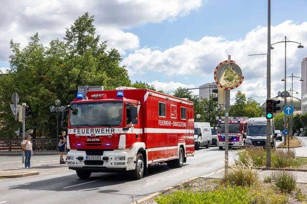 Feuerwehr-Großeinsatz am Nürnberger Opernhaus nach Brand in Tiefgarage, Nürnberg, 09.07.2026 Mehrere Feuerwehrfahrzeuge, darunter ein ELW (Einsatzleitwagen) auf MAN-Fahrgestell, fahren mit Blaulicht zum Einsatzort. Ein brennendes Auto hatte das Feuer ausgelöst, das auf weitere Fahrzeuge übergriff. Das angrenzende Staatstheater wurde wegen starker Rauchentwicklung evakuiert, Statiker prüfen die Stabilität der Tiefgarage. Nürnberg Bayern Deutschland *** Major Fire Department Operation at the Nuremberg Opera House Following a Fire in the Underground Parking Garage, Nuremberg, July 9, 2026 Several fire trucks, including a command vehicle (ELW) on a MAN chassis, are rushing to the scene with their emergency lights flashing. A burning ca 20260709-286A1359-M4000