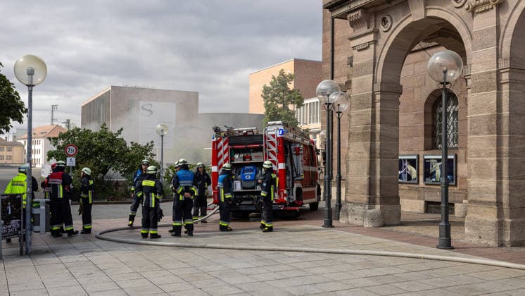 Feuerwehr-Großeinsatz am Nürnberger Opernhaus nach Brand in Tiefgarage, Nürnberg, 09.07.2026 Feuerwehrkräfte sind mit einem Löschfahrzeug vor dem Staatstheater Nürnberg im Einsatz. In der angrenzenden Tiefgarage hatte ein brennendes Auto Feuer gefangen, das auf weitere Fahrzeuge übergriff. Starke Rauchentwicklung aus den Lüftungsschächten erschwert die Lage; das Theater wurde evakuiert, Statiker prüfen die Gebäudesicherheit. Nürnberg Bayern Deutschland *** Large-Scale Fire Department Operation at the Nuremberg Opera House Following a Fire in the Underground Parking Garage, Nuremberg, July 9, 2026 Firefighters are on the scene with a fire truck in front of the Nuremberg State Theater. A burning car had caught fire in the adjacen 20260709-286A1370-M4000