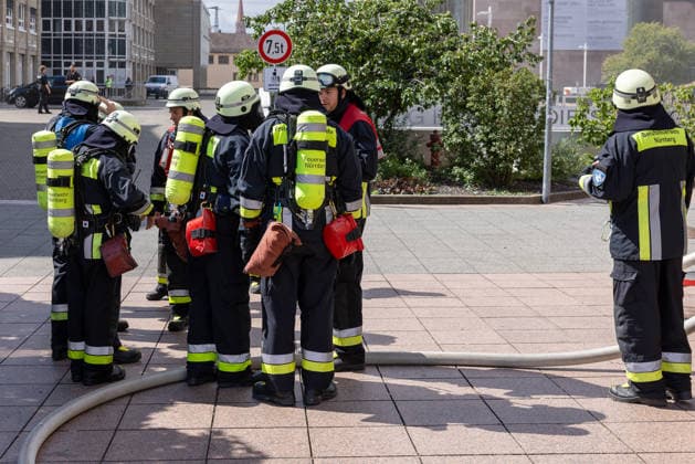 Feuerwehr-Großeinsatz am Nürnberger Opernhaus nach Brand in Tiefgarage, Nürnberg, 09.07.2026 Atemschutzträger der Berufsfeuerwehr und freiwilligen Feuerwehr Nürnberg sammeln sich vor dem Einsatz. Ein brennendes Auto hatte das Feuer ausgelöst, das auf weitere Fahrzeuge übergriff. Starke Rauchentwicklung aus den Lüftungsschächten erschwert die Löscharbeiten; das angrenzende Staatstheater wurde evakuiert. Nürnberg Bayern Deutschland *** Large-Scale Firefighting Operation at the Nuremberg Opera House Following a Fire in the Underground Parking Garage, Nuremberg, July 9, 2026 Firefighters wearing breathing apparatus from the Nuremberg Professional and Volunteer Fire Departments gather before the operation. A burning car had sparked t 20260709-286A1392-M4000