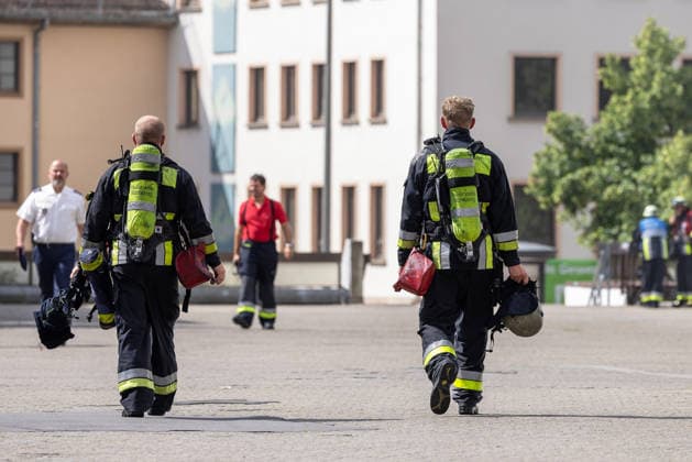 Feuerwehr-Großeinsatz am Nürnberger Opernhaus nach Brand in Tiefgarage, Nürnberg, 09.07.2026 Zwei Atemschutzträger der Feuerwehr kehren nach einem Einsatz in einer Tiefgarage zurück. Auslöser war ein brennendes Auto, das Feuer griff auf weitere Fahrzeuge über. Starke Rauchentwicklung aus Lüftungsschächten erschwerte den Einsatz. Nürnberg Bayern Deutschland *** Major Fire Department Operation at the Nuremberg Opera House Following a Fire in an Underground Parking Garage, Nuremberg, July 9, 2026 Two firefighters wearing breathing apparatus return after responding to a call in an underground parking garage. The fire was caused by a burning car; the flames spread to other vehicles. Heavy smoke coming from ventilation shafts hampered 20260709-286A1406-M4000