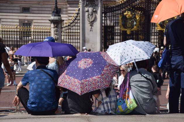 July 9, 2026, London, England, United Kingdom: People shield from the scorching sun under umbrellas outside Buckingham Palace as the UK is hit by another heatwave. London United Kingdom - ZUMAv130 20260709_zip_v130_004 Copyright: xVukxValcicx