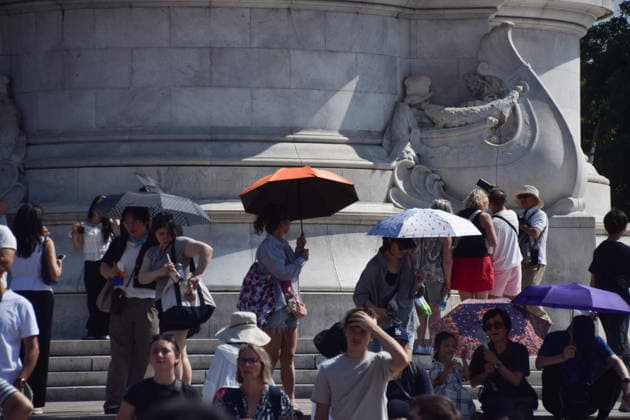 July 9, 2026, London, England, United Kingdom: People shield from the scorching sun under umbrellas outside Buckingham Palace as the UK is hit by another heatwave. London United Kingdom  - ZUMAv130 20260709_zip_v130_013 Copyright: xVukxValcicx