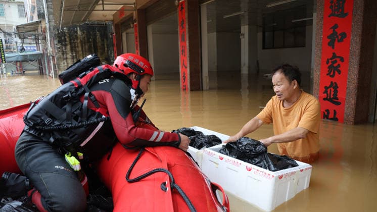 (260709) -- NANNING, July 9, 2026 -- Rescuers deliver relief supplies to trapped residents in Napeng Town of Qinzhou City, south China s Guangxi Zhuang Autonomous Region, July 8, 2026. Recent extreme rainstorms triggered by Typhoon Maysak, the 10th typhoon of the year, have caused severe flooding in parts of Guangxi in the Pearl River basin. Guangxi is continuing its search and rescue operations for missing persons, enhancing resettlement services for affected residents and advancing post-disaster reconstruction. (Photo by Xinhua) FOCUS Guangxi makes all-out rescue, relief efforts after rain-triggered disasters AoxShuaichang 