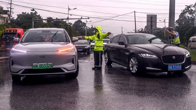 (260709) -- NANNING, July 9, 2026 -- Police officers direct traffic near mud-covered road sections in Qinnan District of Qinzhou City, south China s Guangxi Zhuang Autonomous Region, July 9, 2026. Recent extreme rainstorms triggered by Typhoon Maysak, the 10th typhoon of the year, have caused severe flooding in parts of Guangxi in the Pearl River basin. Guangxi is continuing its search and rescue operations for missing persons, enhancing resettlement services for affected residents and advancing post-disaster reconstruction. ) FOCUS Guangxi makes all-out rescue, relief efforts after rain-triggered disasters ZhangxAilin 