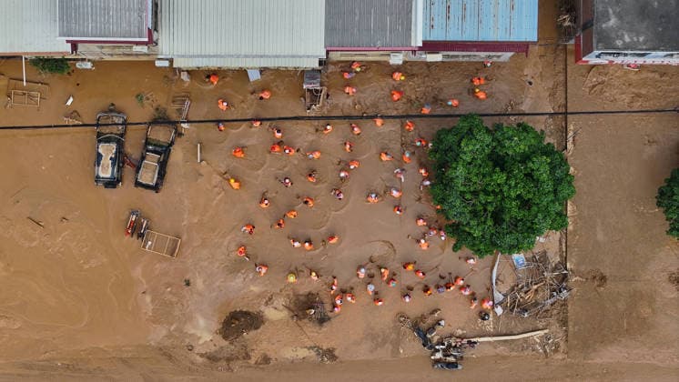 (260709) -- NANNING, July 9, 2026 -- An aerial drone photo shows people removing silt and debris from a street after floodwater recedes in Yunbiao Town of Hengzhou City, south China s Guangxi Zhuang Autonomous Region, July 9, 2026. Recent extreme rainstorms triggered by Typhoon Maysak, the 10th typhoon of the year, have caused severe flooding in parts of Guangxi in the Pearl River basin. Guangxi is continuing its search and rescue operations for missing persons, enhancing resettlement services for affected residents and advancing post-disaster reconstruction. ) FOCUS Guangxi makes all-out rescue, relief efforts after rain-triggered disasters HuangxXiaobang 