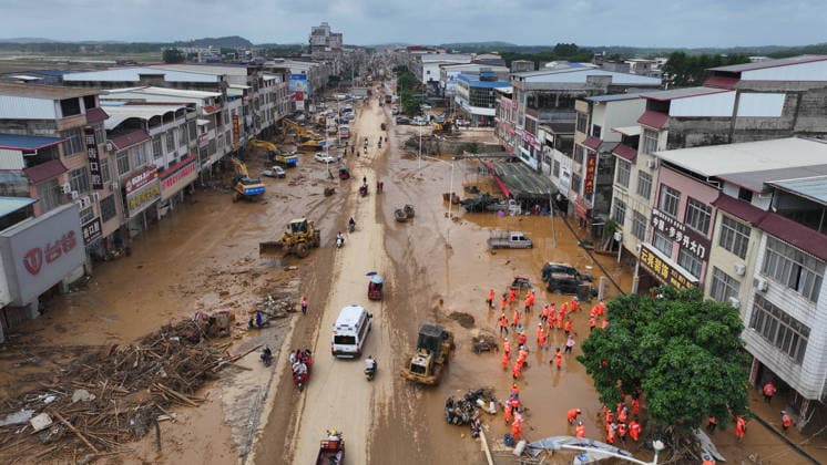(260709) -- NANNING, July 9, 2026 -- A drone photo shows people removing silt and debris from a street after floodwater recedes in Yunbiao Town of Hengzhou City, south China s Guangxi Zhuang Autonomous Region, July 9, 2026. Recent extreme rainstorms triggered by Typhoon Maysak, the 10th typhoon of the year, have caused severe flooding in parts of Guangxi in the Pearl River basin. Guangxi is continuing its search and rescue operations for missing persons, enhancing resettlement services for affected residents and advancing post-disaster reconstruction. ) FOCUS Guangxi makes all-out rescue, relief efforts after rain-triggered disasters HuangxXiaobang 