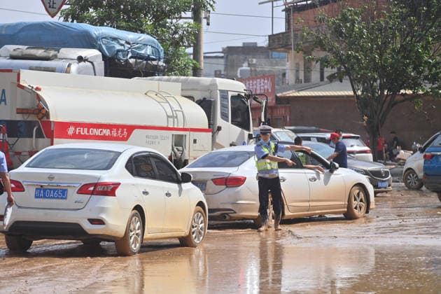 (260709) -- NANNING, July 9, 2026 -- A police officer directs traffic on a street in Yunbiao Town of Hengzhou City, south China s Guangxi Zhuang Autonomous Region, July 9, 2026. Recent extreme rainstorms triggered by Typhoon Maysak, the 10th typhoon of the year, have caused severe flooding in parts of Guangxi in the Pearl River basin. Guangxi is continuing its search and rescue operations for missing persons, enhancing resettlement services for affected residents and advancing post-disaster reconstruction. ) FOCUS Guangxi makes all-out rescue, relief efforts after rain-triggered disasters HuangxXiaobang 