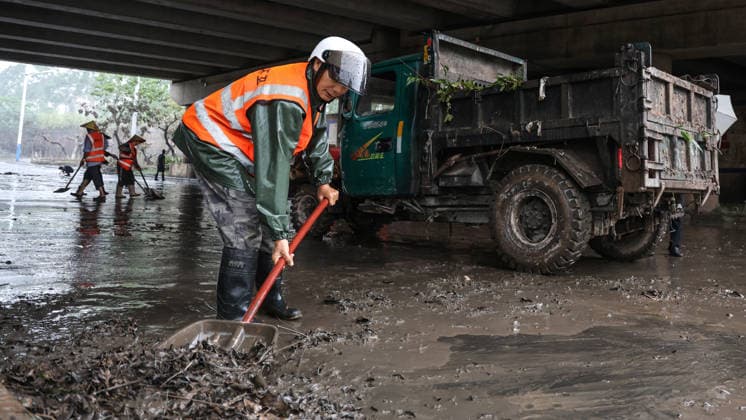 (260709) -- NANNING, July 9, 2026 -- Workers clear silt and debris after floodwater recedes in Qinnan District of Qinzhou City, south China s Guangxi Zhuang Autonomous Region, July 9, 2026. Recent extreme rainstorms triggered by Typhoon Maysak, the 10th typhoon of the year, have caused severe flooding in parts of Guangxi in the Pearl River basin. Guangxi is continuing its search and rescue operations for missing persons, enhancing resettlement services for affected residents and advancing post-disaster reconstruction. ) FOCUS Guangxi makes all-out rescue, relief efforts after rain-triggered disasters ZhangxAilin 
