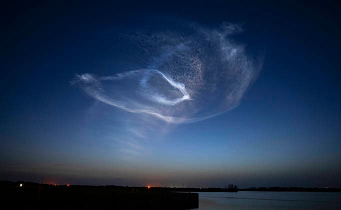 An exhaust plume hangs in the dawn skies after SpaceX launched their Falcon 9 rocket on mission 10-42 at 5.25 AM from Launch Complex 40 at the Cape Canaveral Space Force Station, Florida on Thursday July 9, 2026. Launching on SpaceX s most flown booster, B1067 which has 35 previous missions; 29 Broadband satellites will be flown into low earth orbit.  CCP20260709003 JOExMARINO