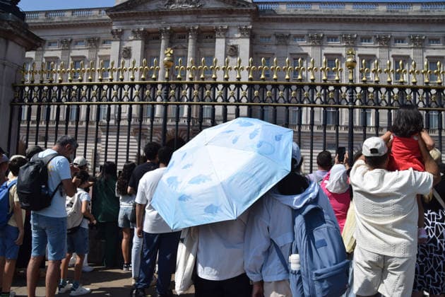 July 9, 2026, London, United Kingdom: People shield from the sun under an umbrella outside Buckingham Palace as the UK is hit by another heatwave. London United Kingdom - ZUMAs197 20260709_aab_s197_002 Copyright: xVukxValcicx