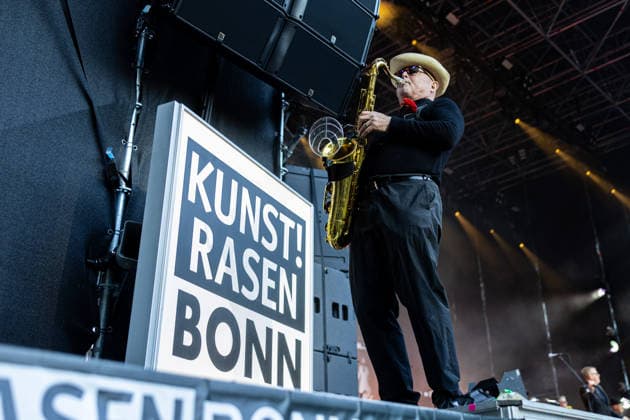 Madness auf dem Kunst!Rasen Bonn Die britische Ska-Pop-Band Madness am Saxophon Lee Thompson beim Live-Auftritt beim Open-Air-Konzert auf dem Kunst!Rasen Bonn-Gronau. Die sommerliche Konzertreihe Kunst!Rasen findet am Rande der Rheinaue am Bonner Rheinufer statt. Bonn Nordrhein-Westfalen Deutschland *** Madness at the Kunst Rasen in Bonn: Lee Thompson on saxophone with the British ska-pop band Madness during a live performance at the open-air concert at the Kunst Rasen in Bonn-Gronau. The summer concert series Kunst Rasen takes place on the edge of the Rheinaue on the banks of the Rhine in Bonn, North Rhine-Westphalia, Germany. Copyright: xMarcxJohnx