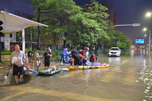 (260710) -- GUIGANG, July 10, 2026 -- Rescuers wade through floodwater to deliver supplies to stranded residents in Guigang, south China s Guangxi Zhuang Autonomous Region, July 9, 2026. Guigang has suffered severe flooding due to torrential rains brought by Typhoon Maysak and upstream inflows. Local authorities have mobilized rescue forces to work around the clock, making every effort to ensure basic living needs for stranded residents. ) CHINA-GUANGXI-GUIGANG-TYPHOON-FLOOD-RESCUE (CN) ZhouxHua 
