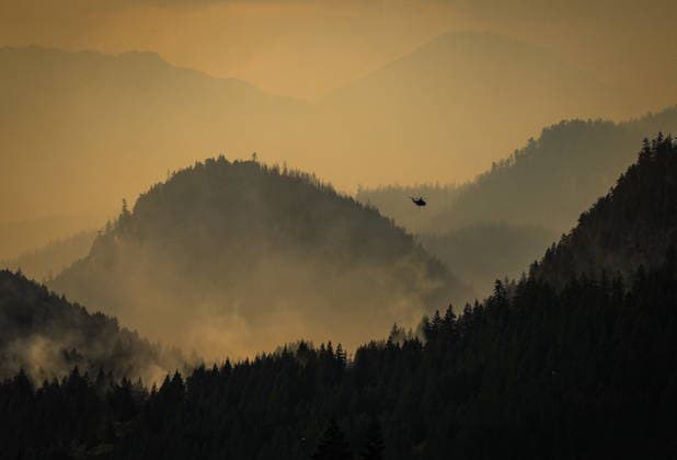 July 9, 2026, Boston Bar, Bc, CANADA: A helicopter being used to fight the Brunswick Creek wildfire prepares to pick up more water as smoke from the Ainslie Creek wildfire is seen in the distance, in Boston Bar, B.C., on Thursday, July 9, 2026. Boston Bar CANADA  - ZUMAc35_ 20260709_zaf_c35_092 Copyright: xDarrylxDyckx
