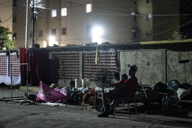 Earthquake survivors continue living in temporary shelters in La Guaira LA GUAIRA, VENEZUELA - JULY 10: A man holds a child while staying outdoors in La Guaira, Venezuela, on July 10, 2026. Residents continue to spend their nights outside after the powerful 7.2 and 7.5 magnitude earthquakes that struck Venezuela in succession on June 24 caused widespread destruction in the coastal city, forcing thousands of people to leave their homes. Cem Tekkesinoglu Anadolu La Guaira Venezuela. Editorial use only. Please get in touch for any other usage.  Copyright: x2026xAnadoluxCemxTekkesinoglux