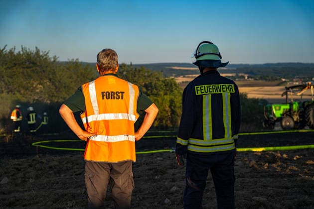 Waldbrand bedroht Acker und Vogelschutzgehölz Garage brennt bei zweitem Einsatz am selben Abend Am 09.07.2026 wurden die Feuerwehren des Hintertaunus gegen 19:54 Uhr zu einem Waldbrand in Usingen alarmiert, bei dem eine 1200 Quadratmeter große Grasfläche brannte. Landwirte verhinderten mit einem Grubber die Ausbreitung auf einen angrenzenden Acker, während die Feuerwehren aus Usingen, Grävenwiesbach und Neu-Anspach die Wasserversorgung sicherstellten und Glutnester per Drohne löschten. Nach etwa zwei Stunden war der Brand gelöscht. Zusätzlich kam es am selben Abend zu einem Garagenbrand in einem Wohngebiet in Neu-Anspach, bei dem die Feuerwehr das Dach der Garage abdeckte, um verborgene Glutnester zu bekämpfen. Usingen Hessen