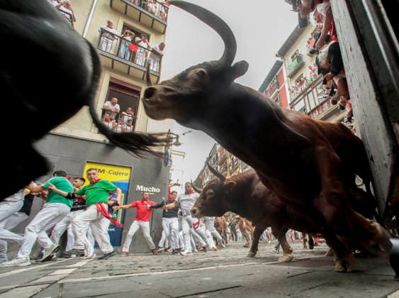 The fighting bulls from the ranch of Alvaro Nunez stampede through the Old City streets in the fourth running-of-the-bulls in Pamplona, northern Spain on Friday, July 20, 2026. Several runners were injured the morning but none were gored.  PAM20260710102 JimxHollander