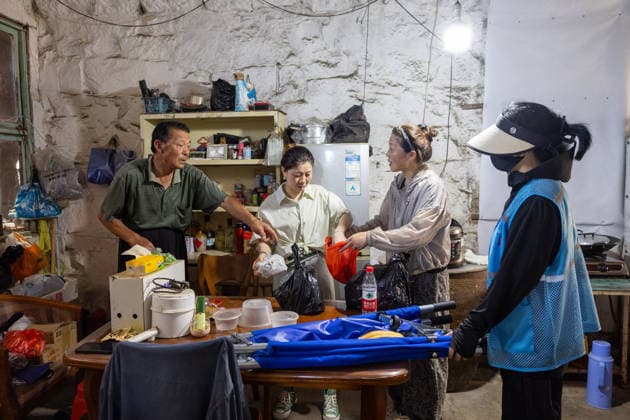 (260710) -- BEIJING, July 10, 2026 -- A volunteer helps people pack their belongings in Wenling, east China s Zhejiang Province, July 10, 2026. China s national observatory on Friday renewed an orange alert for Typhoon Bavi, the ninth typhoon of 2026, which is expected to bring gales and heavy rain to eastern China. Affected regions are on high alert, with all prevention and response measures fully implemented to safeguard people s lives and property. (Photo by Xinhua) CHINA-TYPHOON BAVI-PREVENTION (CN) XuxWeijie 