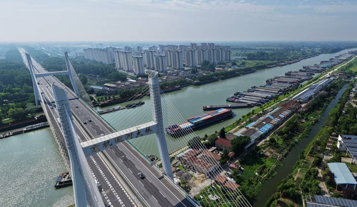 (260710) -- BEIJING, July 10, 2026 -- An aerial drone photo taken on July 10, 2026 shows a panoramic view of vessels mooring along the shore in response to the incoming typhoon at the Grand Canal in Yangzhou, east China s Jiangsu Province. China s national observatory on Friday renewed an orange alert for Typhoon Bavi, the ninth typhoon of 2026, which is expected to bring gales and heavy rain to eastern China. Affected regions are on high alert, with all prevention and response measures fully implemented to safeguard people s lives and property. (Photo by Xinhua) CHINA-TYPHOON BAVI-PREVENTION (CN) MengxDelong 