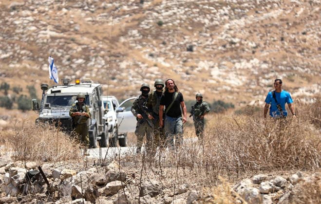 Israeli settlers prevented Palestinian farmers from accessing their agricultural lands in Hebron HEBRON, WEST BANK, PALESTINE - JULY 10: Israeli security forces take measures along the road as Israeli settlers, protected by Israeli forces, block roads leading to Palestinian farmers lands in the town of Izna, near Hebron in the West Bank, Palestine on July 10, 2026. Wisam Hashlamoun Anadolu Hebron West Bank. Editorial use only. Please get in touch for any other usage.  Copyright: x2026xAnadoluxWisamxHashlamounx